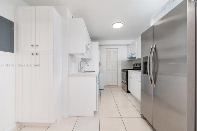 kitchen with light countertops, white cabinetry, under cabinet range hood, a sink, and appliances with stainless steel finishes