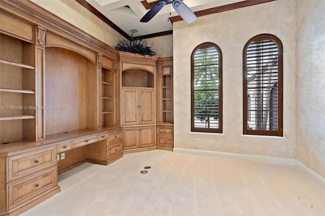 unfurnished office with built in study area, ceiling fan, baseboards, light carpet, and built in features