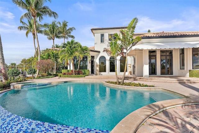 view of swimming pool with french doors, a patio, and a pool with connected hot tub