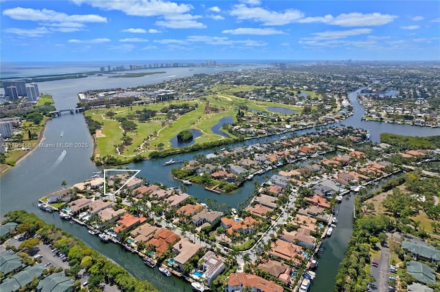 aerial view of property and surrounding area featuring a large body of water and nearby suburban area
