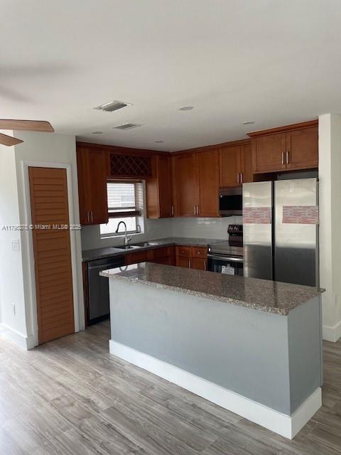 5209 NW 18th St Unit 3E, Lauderhill, FL 33313 - kitchen with a center island, a sink, appliances with stainless steel finishes, and light wood-type flooring