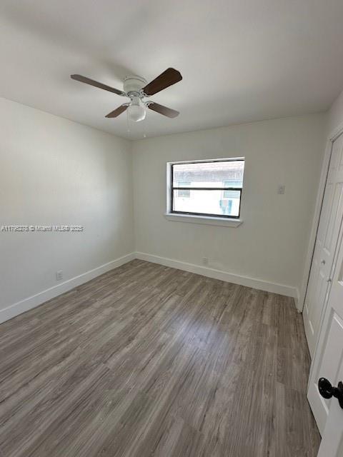 5209 NW 18th St Unit 3E, Lauderhill, FL 33313 - unfurnished bedroom with a ceiling fan, baseboards, wood finished floors, and a closet