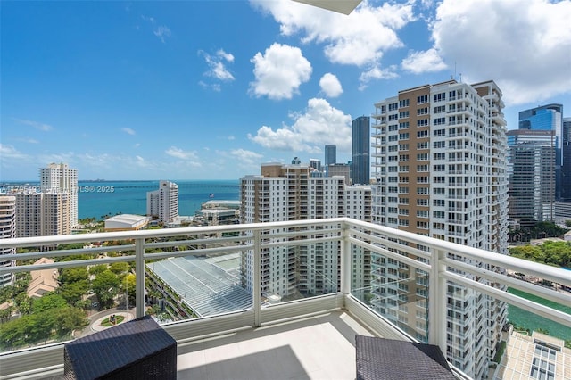 balcony with a water view and a view of city