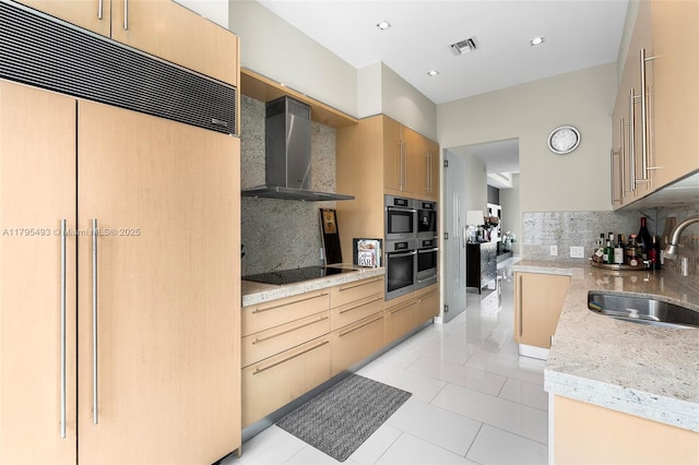 kitchen featuring visible vents, black electric cooktop, a sink, built in refrigerator, and wall chimney exhaust hood