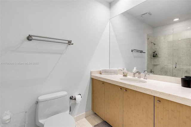 bathroom featuring visible vents, vanity, toilet, baseboards, and a shower stall