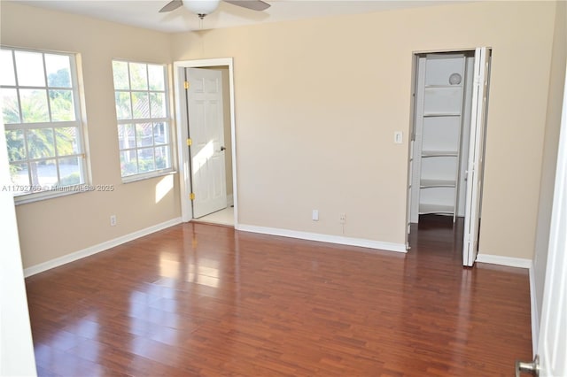 6777 NW 44th Ct, Coral Springs, FL 33067 - unfurnished bedroom featuring baseboards, a walk in closet, and dark wood-type flooring
