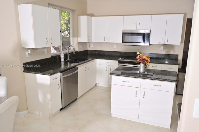 6777 NW 44th Ct, Coral Springs, FL 33067 - kitchen with dark stone countertops, white cabinetry, appliances with stainless steel finishes, and a sink
