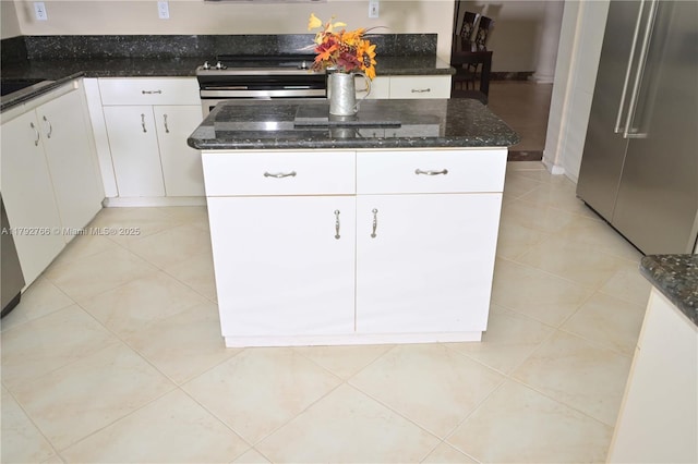 6777 NW 44th Ct, Coral Springs, FL 33067 - kitchen with dark stone counters, white cabinetry, appliances with stainless steel finishes, a kitchen island, and light tile patterned flooring