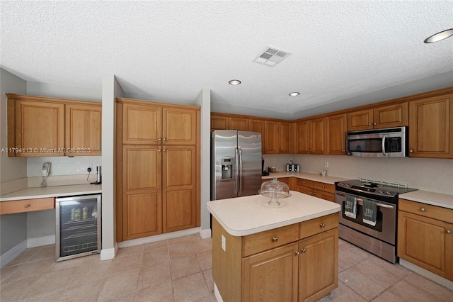 2093 NW 208th Ter, Pembroke Pines, FL 33029 - kitchen with visible vents, beverage cooler, a center island, light countertops, and appliances with stainless steel finishes