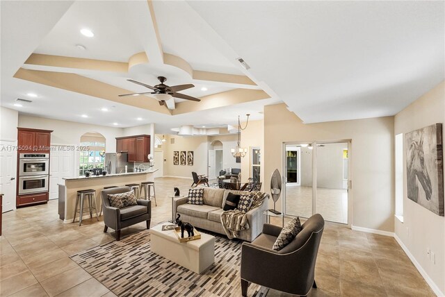 living room featuring recessed lighting, arched walkways, baseboards, and ceiling fan with notable chandelier