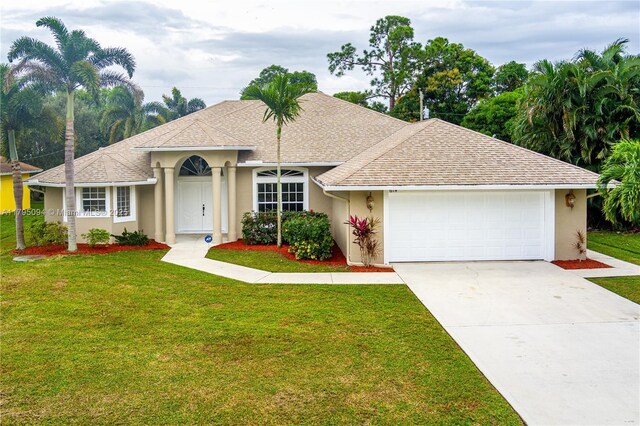 ranch-style house with concrete driveway, an attached garage, a front yard, and stucco siding