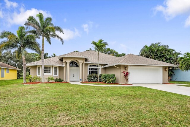single story home featuring driveway, a front lawn, an attached garage, a shingled roof, and stucco siding