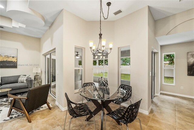 dining space featuring light tile patterned floors, baseboards, visible vents, and an inviting chandelier