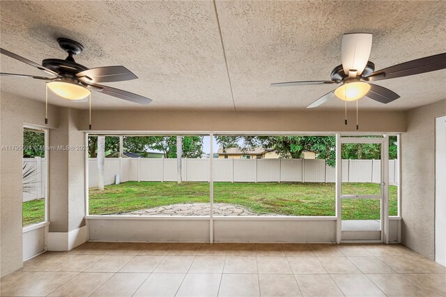 unfurnished sunroom with ceiling fan and a wealth of natural light