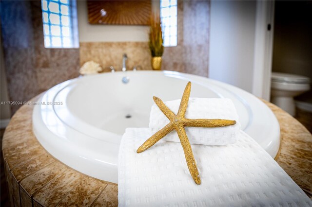 bathroom featuring toilet and a bath