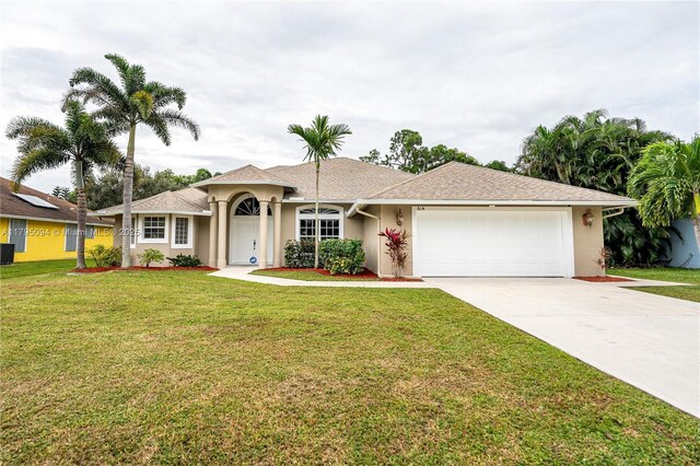 ranch-style home with a garage, a front lawn, stucco siding, and driveway