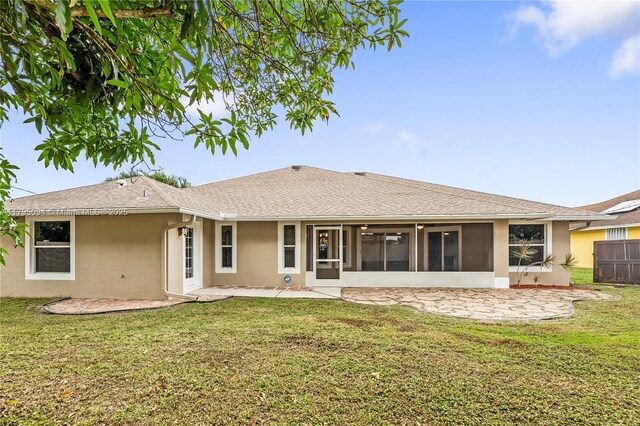 back of house featuring fence, stucco siding, a sunroom, a patio area, and a yard