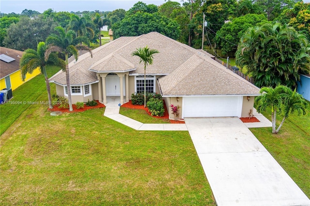 view of front of property featuring an attached garage, a front lawn, stucco siding, and driveway