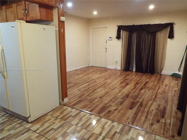spare room with baseboards, recessed lighting, and light wood-style flooring