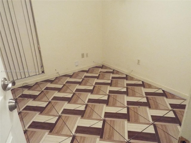unfurnished room with baseboards
