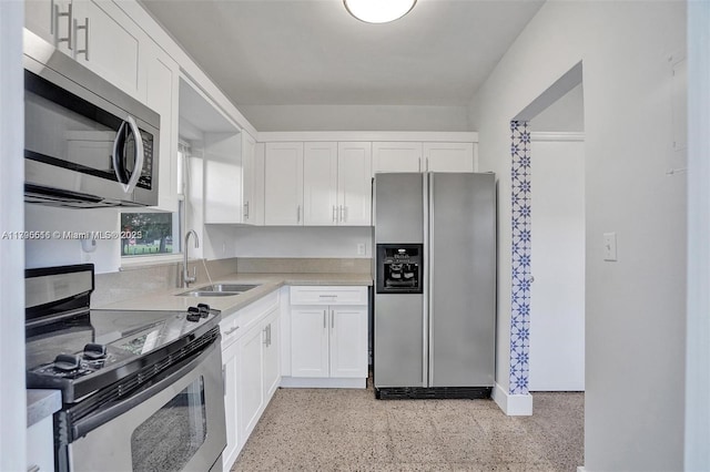 kitchen featuring a sink, white cabinetry, appliances with stainless steel finishes, and light speckled floor