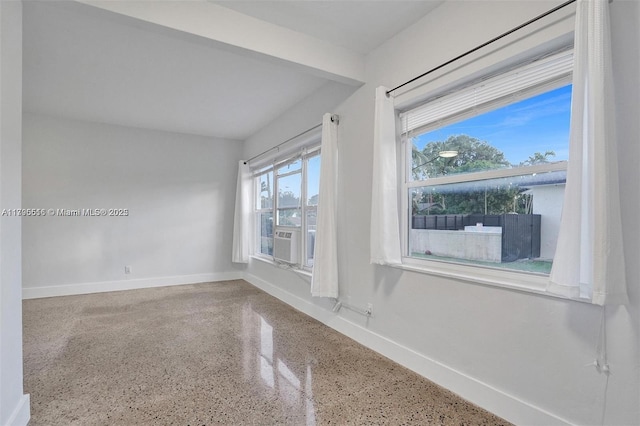spare room with baseboards, speckled floor, and cooling unit