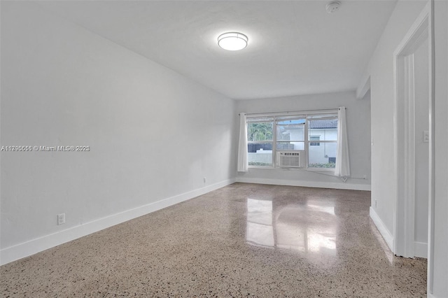 empty room with baseboards and speckled floor