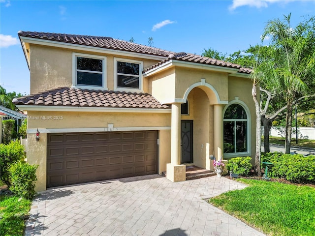 11613 NW 11th Pl, Coral Springs, FL 33071 - mediterranean / spanish-style house featuring stucco siding, an attached garage, decorative driveway, and a tile roof