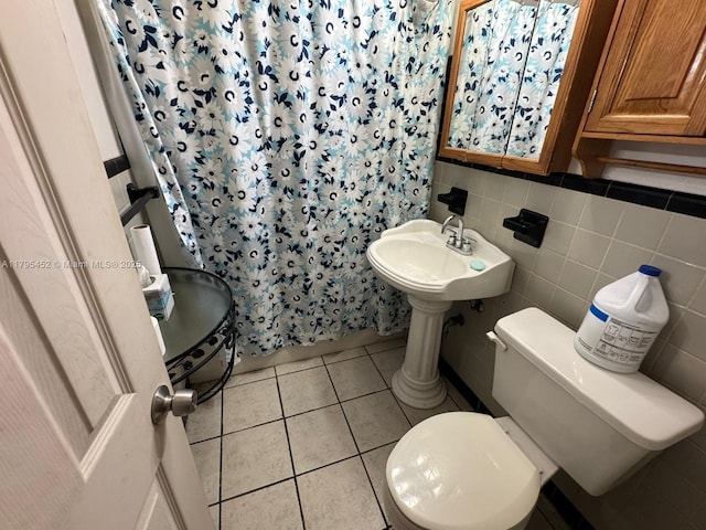 bathroom featuring tile patterned floors, curtained shower, toilet, and tile walls