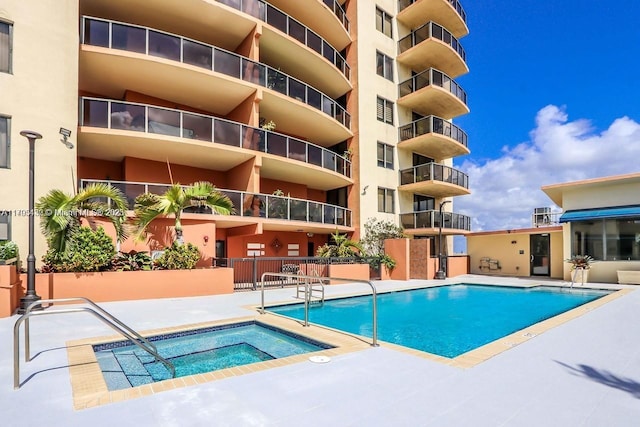 community pool with a patio and a community hot tub