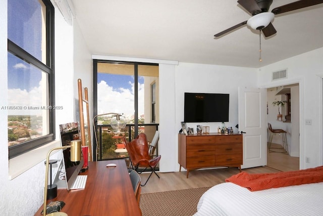 bedroom featuring ceiling fan, visible vents, and wood finished floors