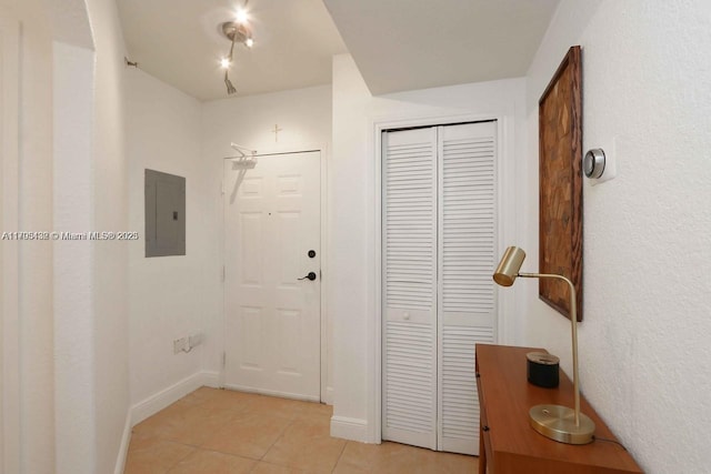entrance foyer featuring baseboards, electric panel, and light tile patterned flooring