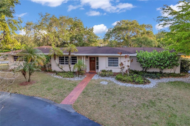 single story home featuring stucco siding and a front lawn