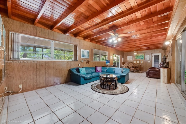 tiled living room featuring wooden ceiling, a ceiling fan, wood walls, and beam ceiling