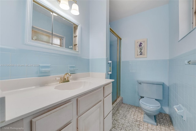 full bathroom with vanity, wainscoting, toilet, tile walls, and a stall shower
