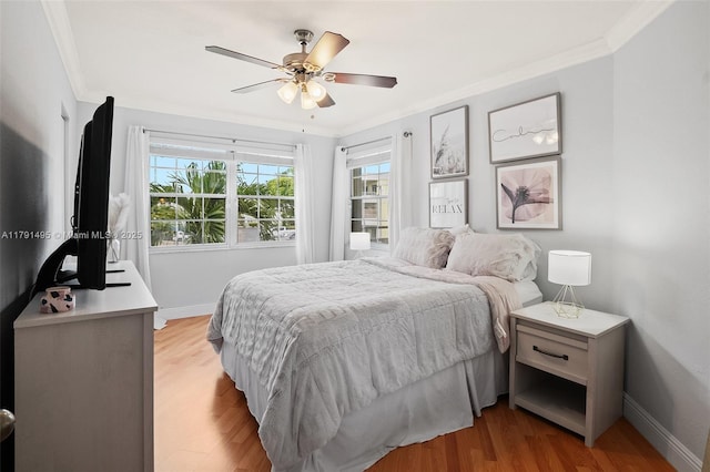bedroom featuring baseboards, ornamental molding, light wood finished floors, and ceiling fan