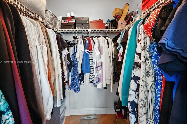 walk in closet with wood finished floors