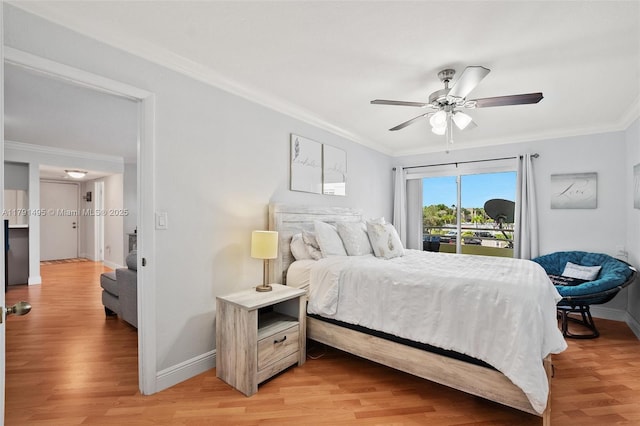 bedroom with crown molding, baseboards, light wood-style floors, and a ceiling fan