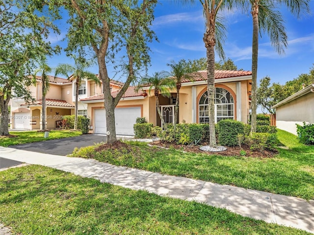 102 Gables Blvd, Weston, FL 33326 - mediterranean / spanish house with stucco siding, asphalt driveway, a front yard, an attached garage, and a tiled roof