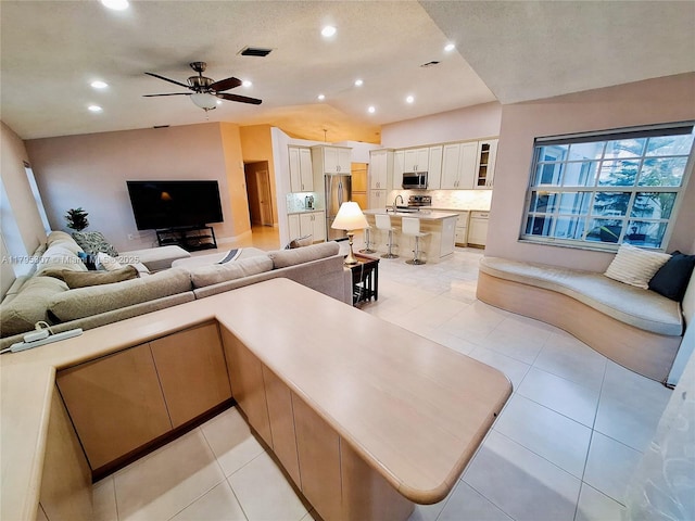 living room with a ceiling fan, recessed lighting, light tile patterned flooring, and visible vents