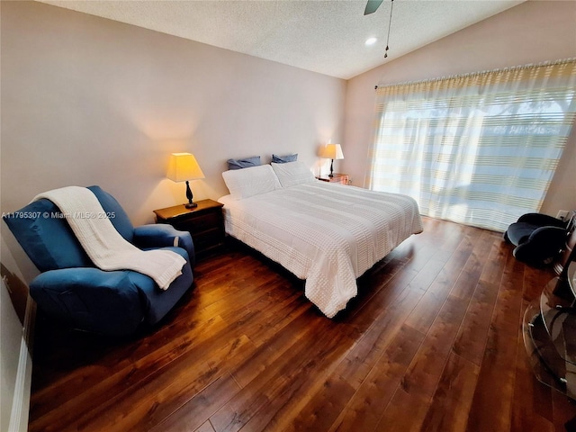 bedroom featuring a textured ceiling, lofted ceiling, and hardwood / wood-style floors