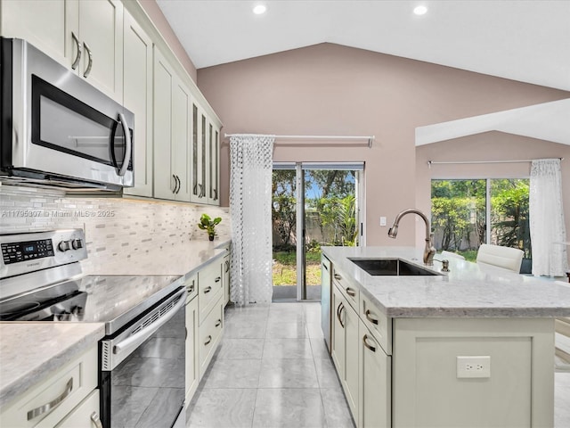 102 Gables Blvd, Weston, FL 33326 - kitchen featuring appliances with stainless steel finishes, a sink, vaulted ceiling, healthy amount of natural light, and decorative backsplash