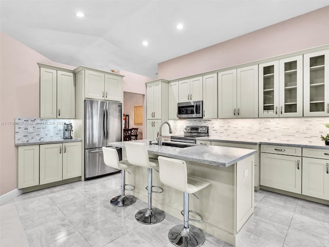 102 Gables Blvd, Weston, FL 33326 - kitchen with stainless steel appliances, a sink, backsplash, a breakfast bar area, and light stone countertops