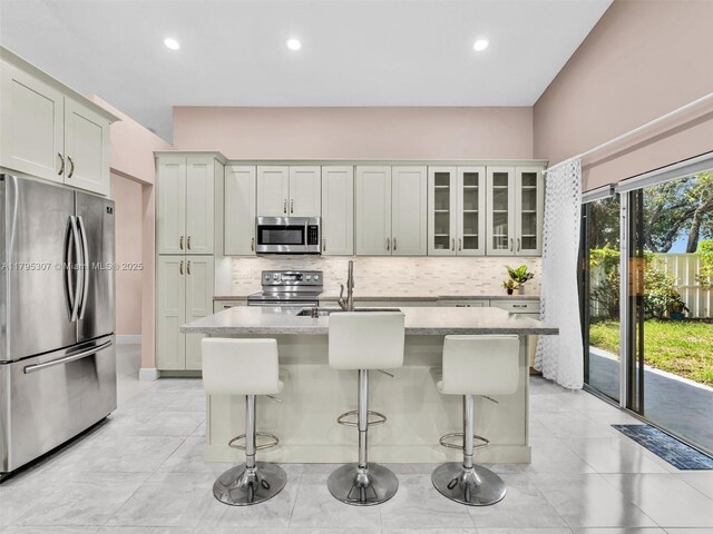 102 Gables Blvd, Weston, FL 33326 - kitchen featuring stainless steel appliances, a sink, tasteful backsplash, a kitchen bar, and recessed lighting