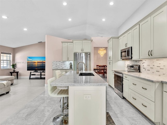 102 Gables Blvd, Weston, FL 33326 - kitchen featuring appliances with stainless steel finishes, tasteful backsplash, a kitchen bar, light stone countertops, and recessed lighting