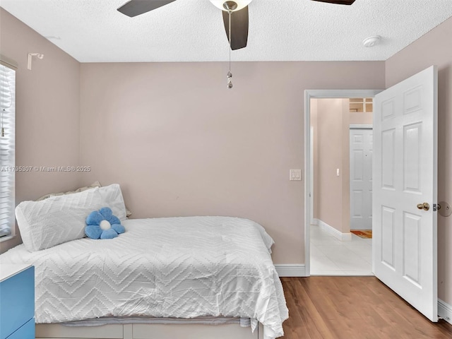 102 Gables Blvd, Weston, FL 33326 - bedroom featuring wood finished floors, a textured ceiling, a ceiling fan, and baseboards