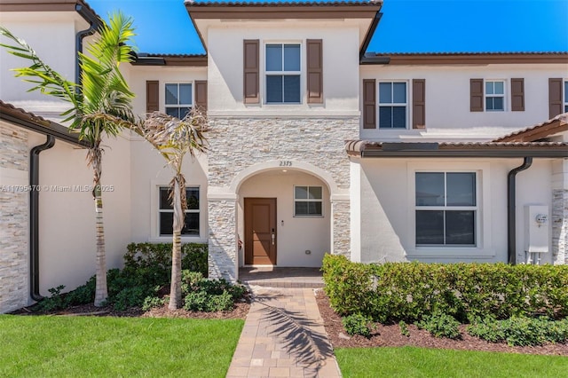 mediterranean / spanish-style home with stucco siding and stone siding