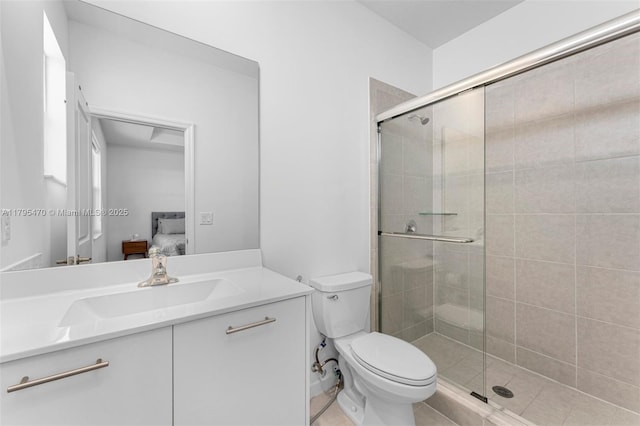 ensuite bathroom with connected bathroom, toilet, a shower stall, and vanity