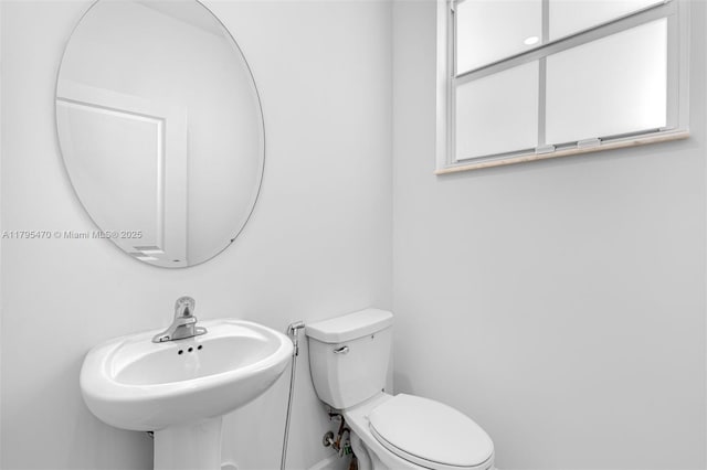 half bath with toilet and a sink