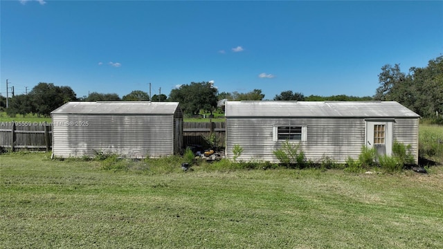 view of yard featuring an outdoor structure, fence, and a storage unit